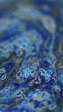 Dikey video. Parlak mürekkep dökülmüş. Akrilik boya. Odaklanmamış mavi altın rengi parlak desen ıslak parlaklık karışık hareket dekoratif soyut sanat arka planı.