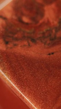 Dikey video. Parıltılı boya döküldü. Mürekkep akıyor. Odaklanmamış bronz kırmızı siyah renk ışıl ışıl sıvı emülsiyon akışı küp geometrik soyut sanat arka planı.