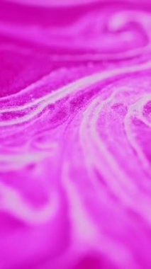 Dikey video. Parlak mürekkep sıçraması. Boya karışımı. Işıl ışıl dökülüyor. Odaklanamayan, parlak, pembe, beyaz tanecikler, doku, sıvı dalga, sanatın soyut arka planını yayıyor..