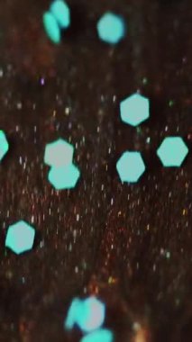 Dikey video. Parıltı dalgası. Boya dökülmüş. Odaklanmamış mavi bronz kahverengi altın rengi parıldayan pullu parçacıklar bokeh hafif dokusu mürekkep akışı su akışı soyut sanat arka planı.