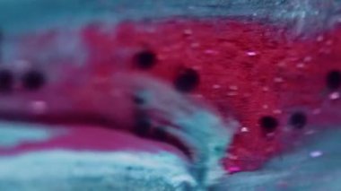 Dikey video. Boya dökülmüş. Parlak sıvı damlası. Odaklanmamış parlak mavi siyah renk parlak pullu partiküller metalik mürekkep akış hareketi soyut sanat arkaplanı.