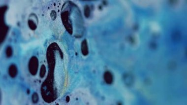 Dikey video. Renk köpüğü dokusu. Fizz sıvısı. Bulanık mavi, sarı, parlak, parlak boya baloncukları dalga hareketlerinin soyut sanat arkaplanını karıştırıyor..