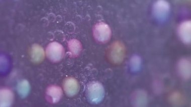 Pastel boncuklar. Şampuan boyası. Parıldayan köpükler içinde yüzen çoklu renk baloncukları. Yumuşak bilyeler. Islak parlak sabun emülsiyonu soyut sanat arka planı..