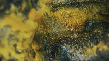 Parıldayan sıvı damlası. Boya karışımı. Bulanık, altın sarısı, parlak yağ lekesi soyut sanat arkaplanı..