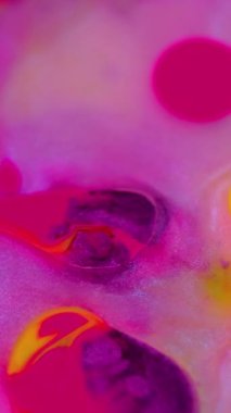 Dikey video. Su damlasını boya. Parlak sıvı kabarcıkları. Bokeh hafif desen soyut sanat arka planında odaksız parlak mor mor renkli pırıl pırıl mürekkep karışımı hareket.