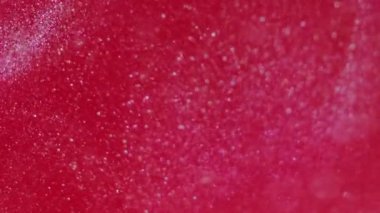 Parlak sıvı. Damla mürekkebi. Odaklanmamış mercan kırmızısı, lüks su emülsiyonunda ışıl ışıl parıldayan parlak parlak kozmetik parçacıkları soyut sanat arka planı..