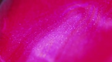Islak sim dökülmüş. Metalik sıvı. Bulanık neon parlak morumsu pembe parıldayan sıvı boya damlaları soyut sanat arka planı.