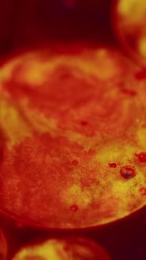 Dikey video. Parıldayan kabarcıklar. Boya çemberleri. Güneş yörüngesi. Parlak, kırmızı, parlak, kırmızı, parıldayan küre, yağ, mürekkep, koyu soyut sanat arka planında girdap..