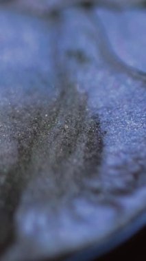 Dikey video. Mürekkep damlası. Parlak sıvı sıçraması. Bulanık mavi renkli parlak desenli akrilik boya emülsiyon dalgası hareketli soyut sanat arka planını ortaya çıkardı.