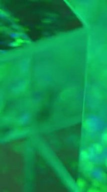 Dikey video. Neon küp. Renkli flaş. Odaklanamayan şeffaf cam kare bokeh gökkuşağı daireler sarı yeşil mavi pembe parlaklıklar soyut arkaplan boşluğu.