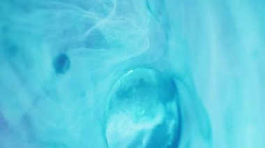Su boyası akıyor. Su kabarcığı. Bulutlu sıvı. Yüzen yağ damlaları ile yarı saydam mavi beyaz mürekkep emülsiyonu hareketli soyut sanat arkaplanı.