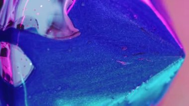 Dikey video. Parlak mücevher. Parlak boya dökülmüş. Odaklanmamış neon açık mavi renkli parlak desen mürekkebi şeffaf cam prizması soyut sanat arka planı.