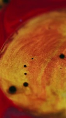 Dikey video. Parıldayan sıvı. Boya baloncukları. Parlak, kırmızı, mor, pırıl pırıl, parlak desen, yağlı, mürekkep karışımı, girdaplı, soyut sanat arkaplanı..