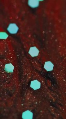 Dikey video. Parlak doku. Sequin boyası. Odaklanmamış mavi bronz siyah renk parıldayan parçacıklar bokeh ışık mürekkebi akışı soyut sanat arkaplanı.