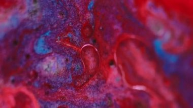 Yüzen damla. Islak mürekkep. Odaklanmamış kırmızı mavi renk parıldayan sıvı yarı şeffaf yağ kabarcıkları parıldayan parlak sıvı akış hareketi soyut sanat arka planı.