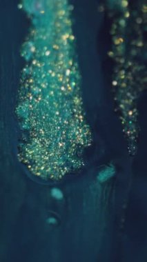 Dikey video. Parıltılı boya döküldü. Mürekkep fraktal. Odaklanmamış mavi altın rengi parıldayan parçacıklar dokusu sıvı akışı simetrik tasarım soyut sanat arkaplanı.