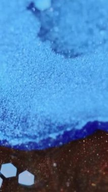 Dikey video. Parıltı dalgası. Boya dökülmüş. Odaklanmamış mavi bronz kahverengi altın rengi metalik parıldayan pullu desen akrilik mürekkep akışı su akışı soyut sanat arka planı.