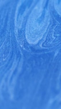 Dikey video. Mürekkep dök. Işıltılı girdap. Mavi soyut parlak dalgalar beyaz lekeler ışıl ışıl parçacıklar sanat fraktal desenli arkaplan çözünmüş boşluk.