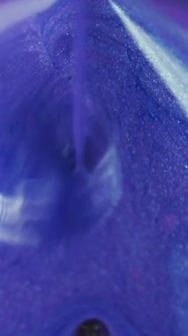 Dikey video. Parıltılı piramit. Boya dökülmüş. Odaklanmamış neon mavisi altın rengi parıldayan parçacıklar desen mürekkebi hareketli geometrik soyut sanat arkaplanı dökülüyor.