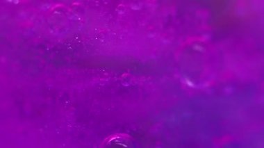 Disko boyası. Su kabarcıkları mürekkep. Odaklanmamış yanardöner mor renk floresan parıltı sıvısı köpük emülsiyon hareketi soyut sanat arka planı.