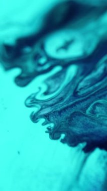 Dikey video. Boya suyu akışı. Mürekkep karışımı. Odaklanmamış mavi renk emülsiyon toz toz tanecikleri sıvı sıvı dalga hareketi soyut sanat arkaplanı.