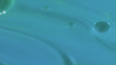 Köpük emülsiyonu. Köpüklü sıvı. Odaklanmamış mavi renk şeffaf yuvarlak damlacıklar yüzen jel dokusu boya su akışı hareket soyut sanat arka planı.