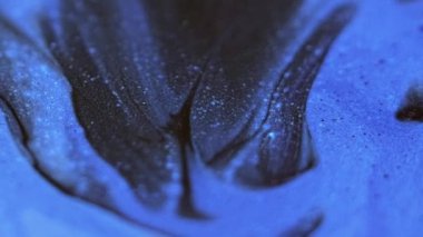 Köpüklü boya karışımı. Parıltı dökülüyor. Odaklanmamış siyah mavi renk parıldayan parçacıklar dokusu akrilik dalga hareketi soyut sanat arkaplanı.