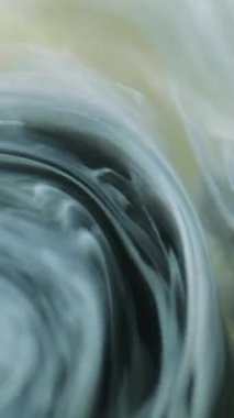 Dikey video. Duman girdabı. Su altı boyası. Odaklanmamış beyaz gri sis bulutu mürekkep suyu karışımı sarmal hareketli ipek sıvı girdap sanat soyut arkaplan.