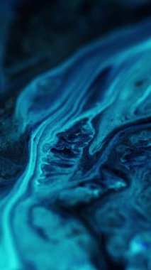 Dikey video. Akrilik boya karışımı. Parlak mürekkep. Odaklanmamış mavi renkli parlak toz parçacıkları doku sızıntısı su sıvısı harmanlanmış hareket soyut sanat arka planı.