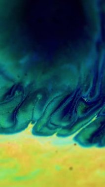 Dikey video. Boya akışı. Köpüklü sıvı dalgası. Odaklanmamış mavi çivit mavisi, altın rengi, parlak toz dokusu, simli, sıvı mürekkep emülsiyonu, su karışımı, soyut sanat arka planı..