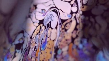 Psikedelik boya. Benzin yağı. Odaklanmamış sarı pembe renkli gökkuşağı damlacıkları koyu siyah soyut sanat arka planında kaygan bir hareket harmanlarlar.