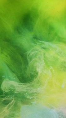 Dikey video. Duman karışımı. Boya suyu akışı. Asit mürekkebi. Parlak neon yeşil beyaz renk sıvı girdap akrilik buhar bulutu hareket sim toz soyut sanat arka planı.