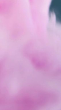 Dikey video. Boya suyu girdabı. Sihirli karışım. Duman hortumu. Bulanık pembe macenta rengi pastel sis mürekkep girdaplı bulut sarmalı akış sanatı soyut arka plan.