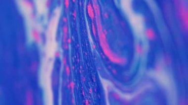 Köpüklü boya. Parlak mürekkep akışı. Odaklanmamış mavi pembe renk parıldayan tahıl parçacıkları akrilik sıvı karışımı sıvı dalga hareketi soyut sanat arka planı.
