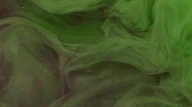 Işıldayan boya sıçraması. Duman bulutu. Odaklanmamış yeşil renk parçacıkları parlak doku patlama buharı akışı hareket soyut sanat arkaplanı ortaya çıkarıyor.