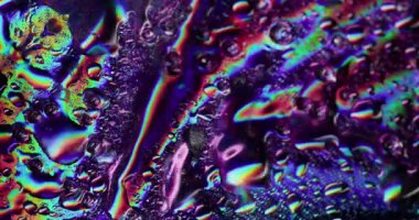 Akan damlalar. Islak yüzey. Yanardöner camların üzerindeki renkli akarsular. Suyun spektrum ışığı kaotik işaret fişeği parlayan nem oyunuyla yansımaları değiştiriyor.