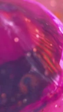 Dikey video. Neon prizması. Islak, ışıl ışıl bir doku. Odaklanmamış mor menekşe renk holografi kristali parlak sıvı parıltı partikülleri yanardöner ışık soyut sanat arkaplanı damlatıyor.