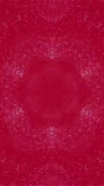Dikey video. Kaleydoskop boyası. Mürekkep süsü. Odaklanmamış pembe renk, parıldayan sıvı, parıldayan simetrik geometrik desen, soyut sanat arkaplanı..