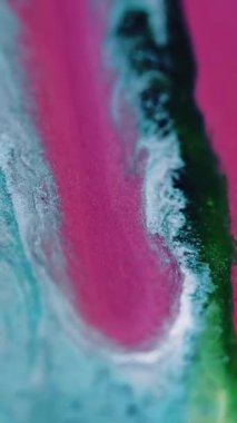 Dikey video. Islak sim damlası. Boya dökülmüş. Odaklanmamış pembe mavi renk parıldayan parçacıklar desen mürekkep sızıntısı hareket soyut sanat arkaplanı.