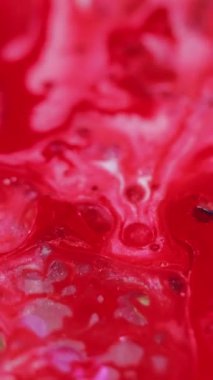 Dikey video. Mürekkep kaleydoskop. Boya süsü. Odaklanmamış kırmızı parlak yağ damlaları sıvı parıltılı emülsiyon ışıltılı simetrik desen soyut sanat arka planı.