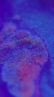 Dikey video. Neon sıvısı. Parlak boya dalgası. Odaklanmamış pembe renkli parlak desenli mürekkep karışımı sızıntı hareketi soyut sanat arkaplanı.