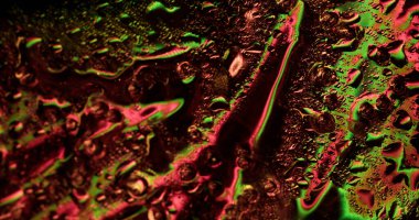 Folyo sıvısı. Islak yüzey. Yanardöner camların üzerindeki renkli akarsular. Suyun spektrum ışığı kaotik işaret fişeği parlayan nem oyunuyla yansımaları değiştiriyor.