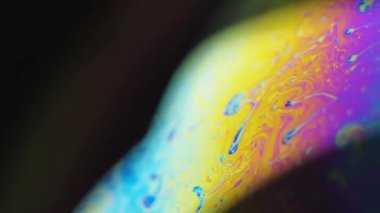 Benzin yağı. Psikedelik spektrum. Koyu siyah soyut sanat arka planında çözünmüş sarı mavi renk eğrisi yağ kimyasal sıvı akış hareketi.