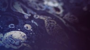 Akrilik dökülmesi. Köpüklü su. Odaklanmamış mavi turuncu yağ dokusu emülsiyon damlacıkları koyu siyah ışık parlaması üzerinde yüzer soyut sanat arkaplanı.