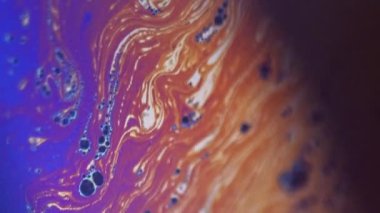 Boya karışımı. Köpük sıvısı. Odaklanmamış mavi turuncu gökkuşağı renk damlacıkları koyu siyah soyut sanat arka planında dalga hareketini harmanlarlar.