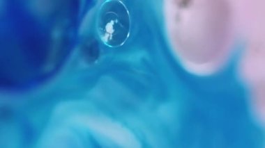 Dikey video. Yağ sıvısı. Su damlasını boya. Odaklanmamış mavi pembe renk şeffaf yuvarlak kabarcıklar yüzen jel dokusu akış hareketi soyut sanat arkaplanı.