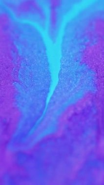 Dikey video. Mürekkep döküldü. Sıvı sim dokusu. Odaklanmamış neon mavi renk parıldayan kum parçacıkları akrilik boya sızıntısı pigment akışkan hareket soyut sanat arka planı.