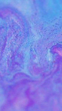 Dikey video. Parlak bir dökülme. Akrilik sıvı akışı. Odaklanmamış mor renkli parıldayan kum parçacıkları sıvı emülsiyon karışımı dalga hareketini soyut sanat arka planına boyarlar..