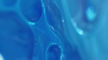 Dikey video. Yağ kabarcıkları. Köpüklü sıvı. Odaklanmamış mavi beyaz renk şeffaf yuvarlak damlacıklar yüzen jel dokusu boya su akışı hareketli soyut sanat arka planı.
