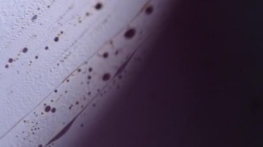 Kimyasal sıvı. Köpük sıvısı. Odaklanmamış mor renkli köpüklü desenli koyu siyah ışık parlaklığında karışık boya dalgası soyut sanat arkaplanı.